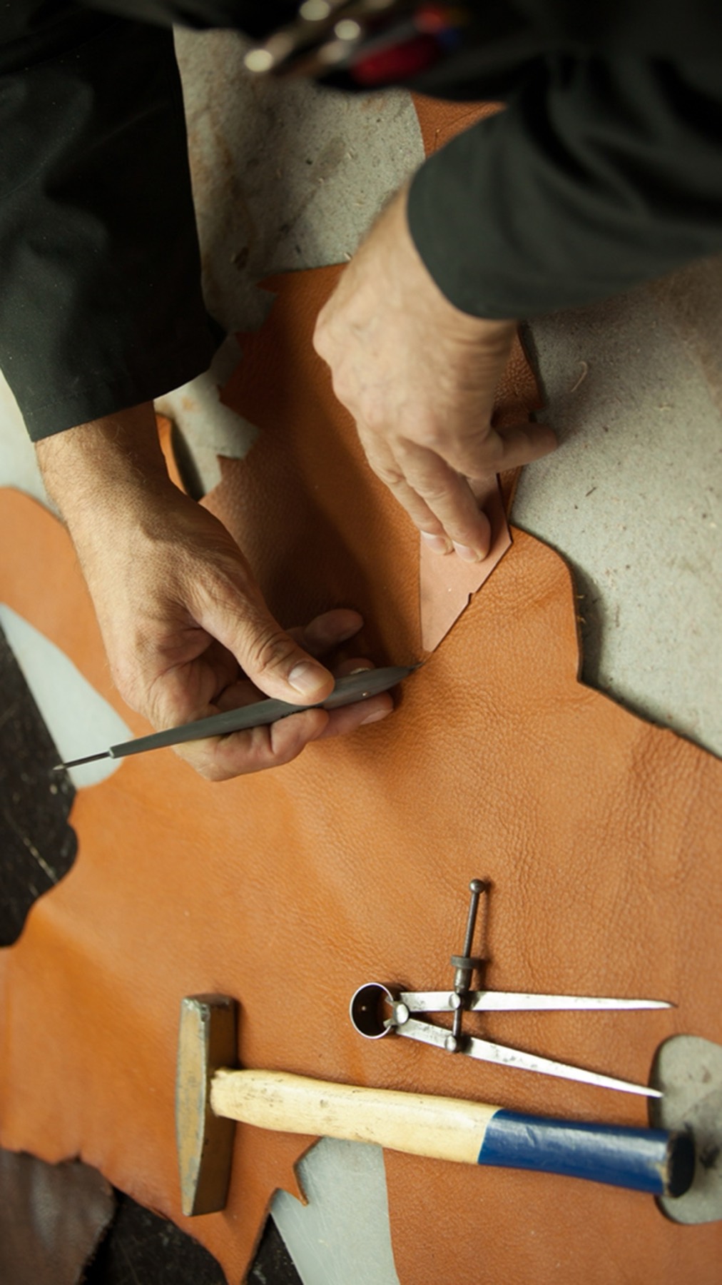 Hands cutting and marking leather
